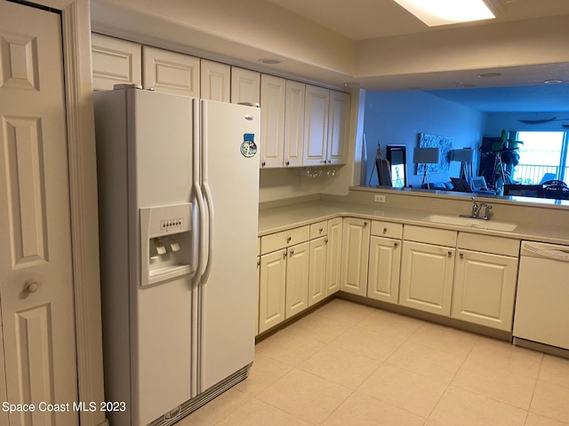 kitchen featuring white cabinets, light tile flooring, white appliances, and sink