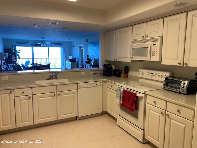 kitchen with white appliances, white cabinets, and ceiling fan