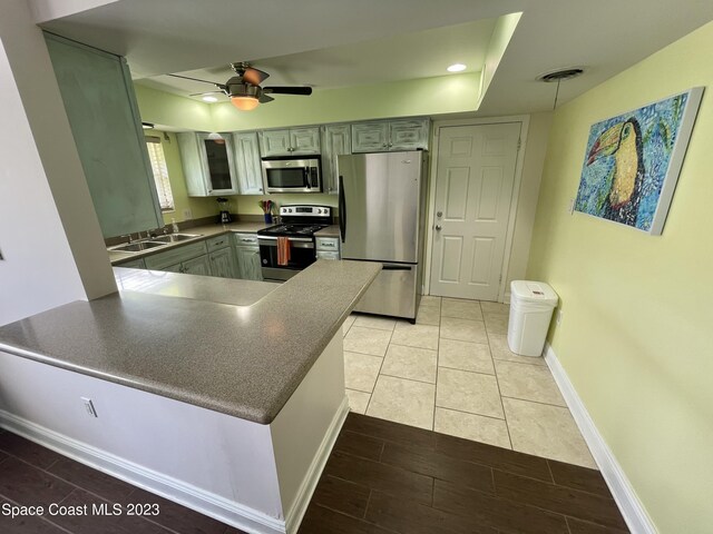 kitchen featuring ceiling fan, light tile floors, sink, gray cabinetry, and stainless steel appliances