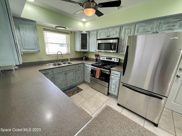 kitchen with ceiling fan, gray cabinets, sink, light tile floors, and stainless steel appliances