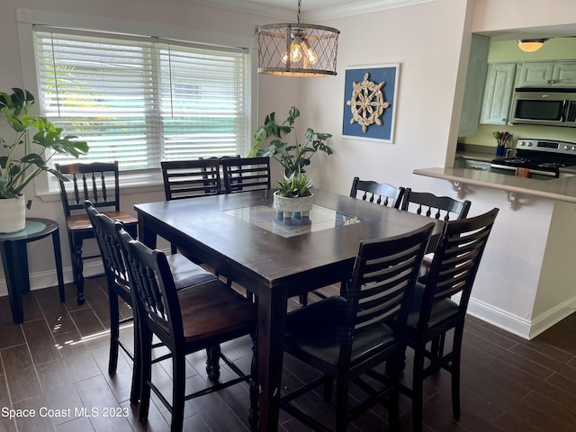 dining space with dark hardwood / wood-style flooring and ornamental molding