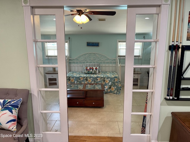 bedroom with light tile floors, multiple windows, and ceiling fan