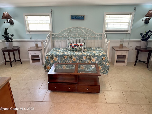 bedroom featuring light tile flooring and multiple windows