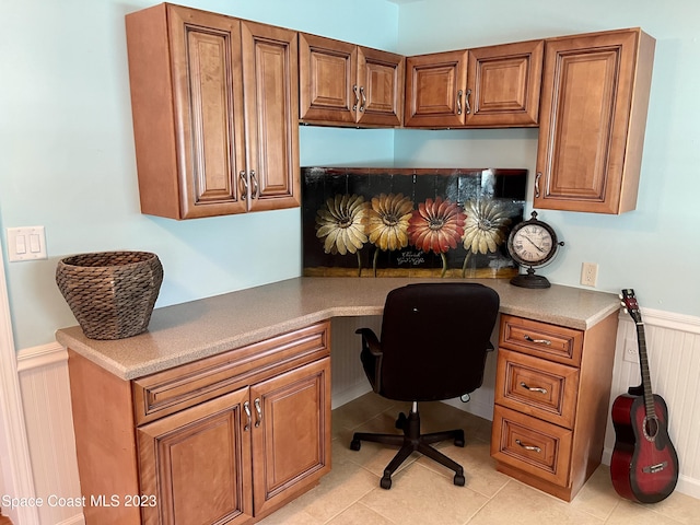 office space featuring built in desk and light tile floors