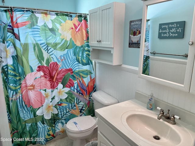 bathroom with toilet and vanity with extensive cabinet space