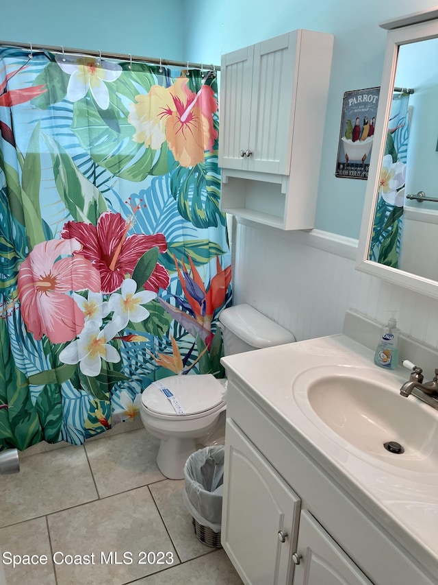 bathroom featuring toilet, tile floors, and vanity with extensive cabinet space