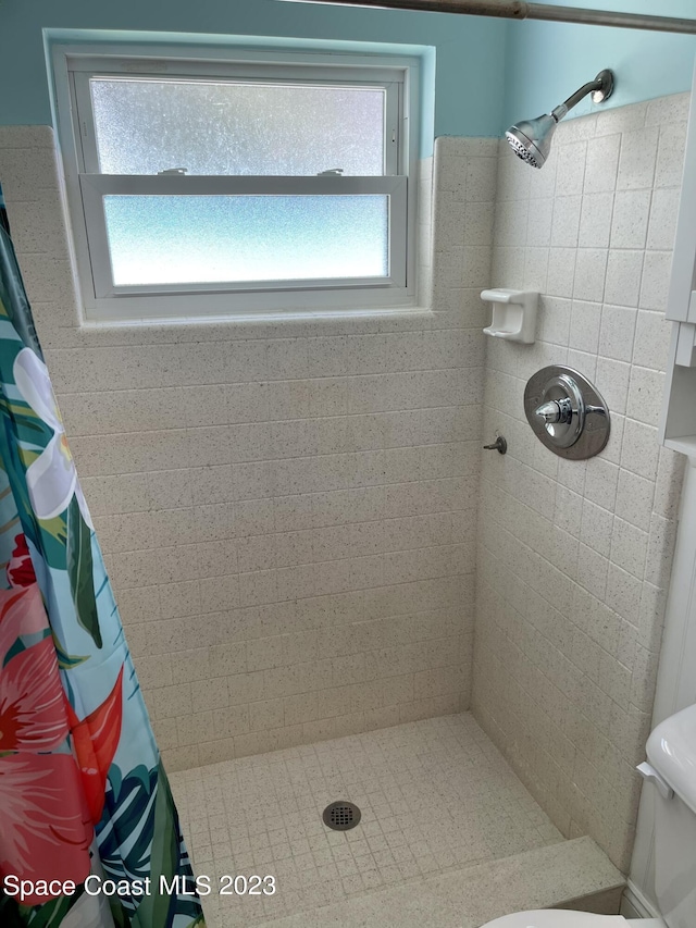 bathroom featuring a shower with curtain and toilet