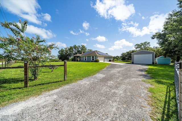 single story home featuring an outdoor structure, a front yard, and a garage