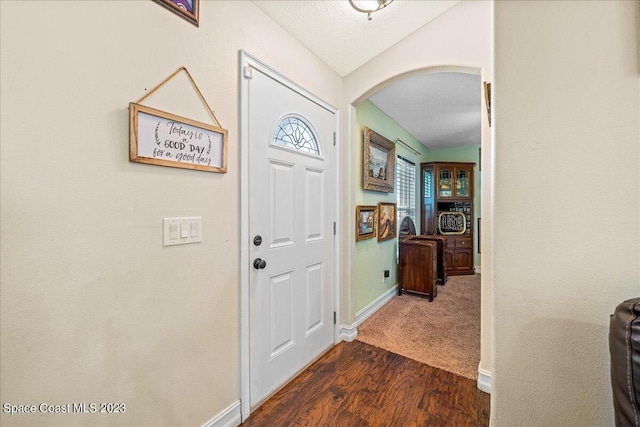 foyer featuring a textured ceiling and dark wood-type flooring