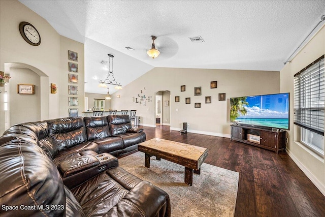 living room featuring ceiling fan, a textured ceiling, high vaulted ceiling, and dark wood-type flooring