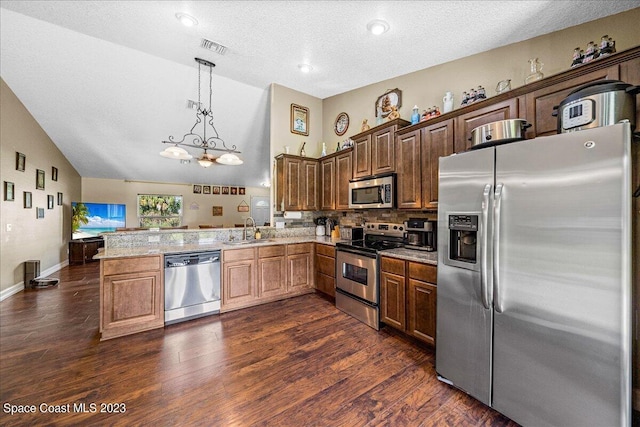 kitchen with kitchen peninsula, stainless steel appliances, hanging light fixtures, and dark wood-type flooring