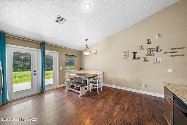 dining room with a textured ceiling, dark hardwood / wood-style floors, and vaulted ceiling