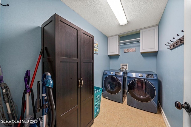 clothes washing area featuring light tile flooring, a textured ceiling, cabinets, hookup for a washing machine, and independent washer and dryer