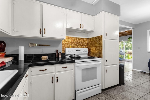 3706 Sutton Dr, Orlando, FL 32810 - kitchen with light tile floors, white cabinetry, white range with electric stovetop, and range hood