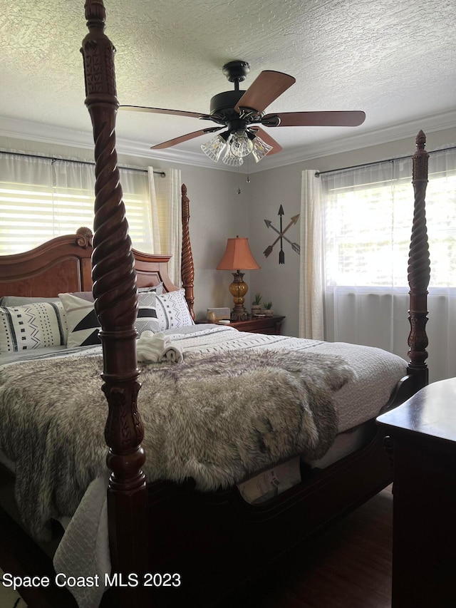 bedroom featuring ceiling fan, a textured ceiling, and crown molding