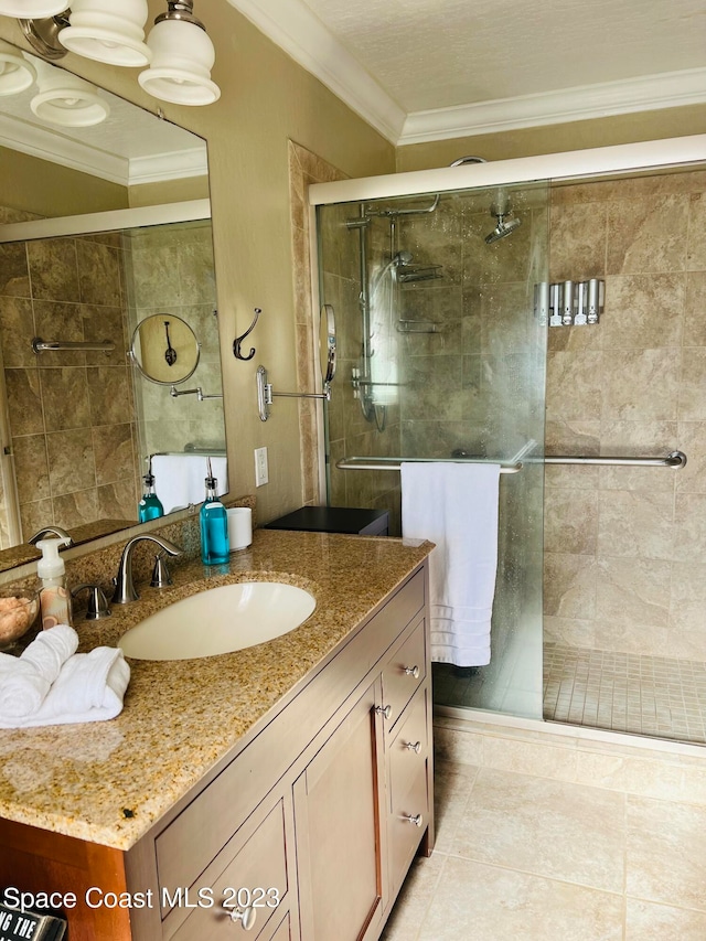 bathroom with vanity, tile floors, crown molding, and walk in shower