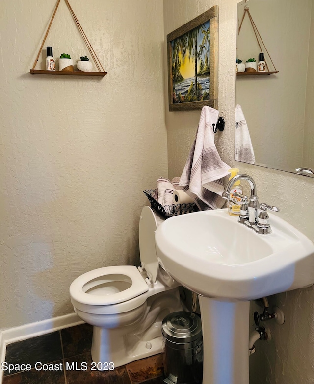 bathroom featuring toilet and tile floors