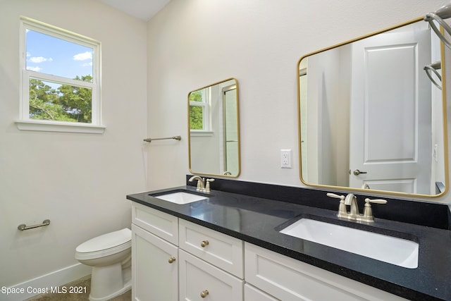 bathroom with double sink vanity and toilet