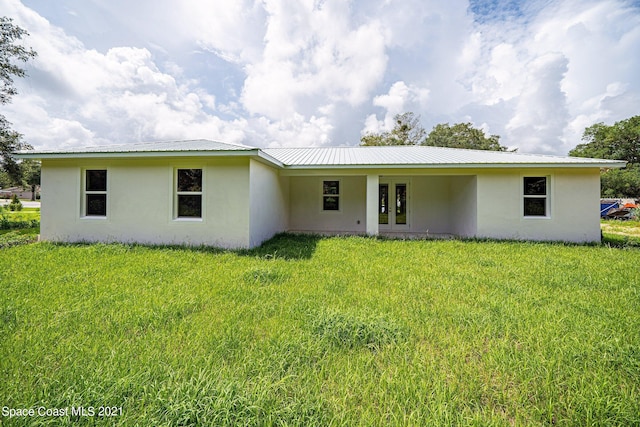 rear view of property featuring a yard