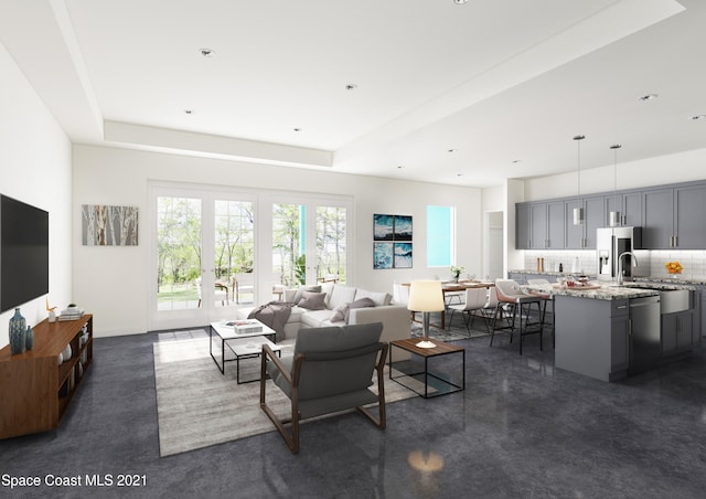 living room featuring a raised ceiling and sink