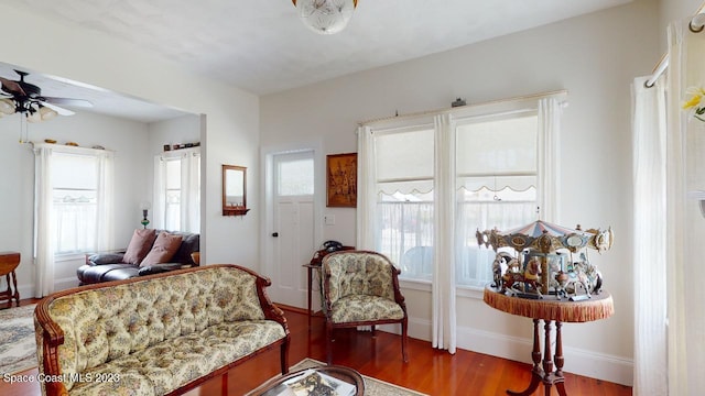 living room with ceiling fan and dark hardwood / wood-style floors