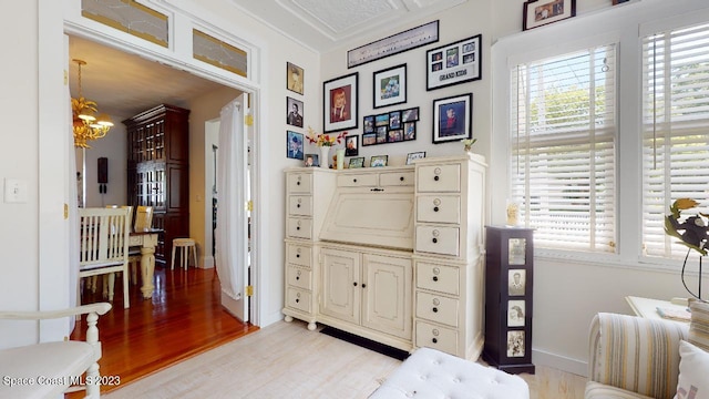 bedroom featuring a chandelier, ornamental molding, and light wood-type flooring