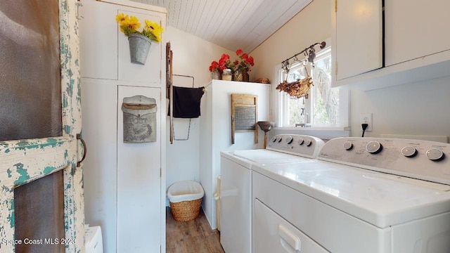 clothes washing area with light hardwood / wood-style floors and washer and clothes dryer