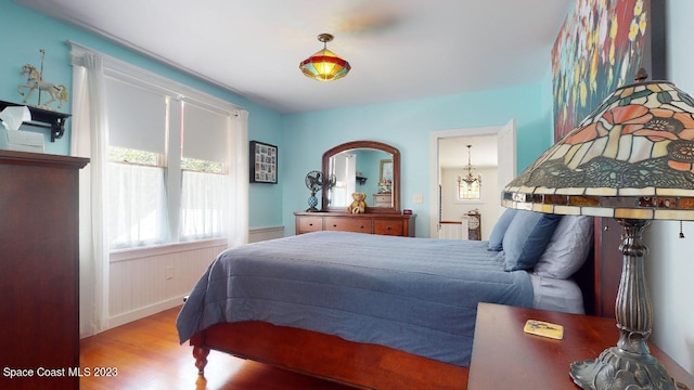 bedroom with an inviting chandelier and light wood-type flooring