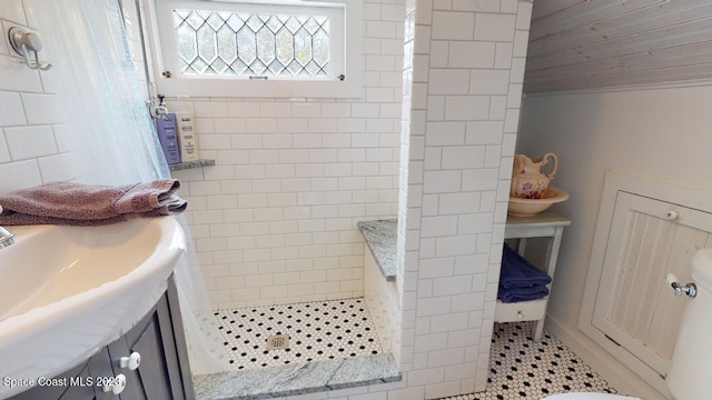 bathroom featuring tile walls, tiled shower, and tile flooring