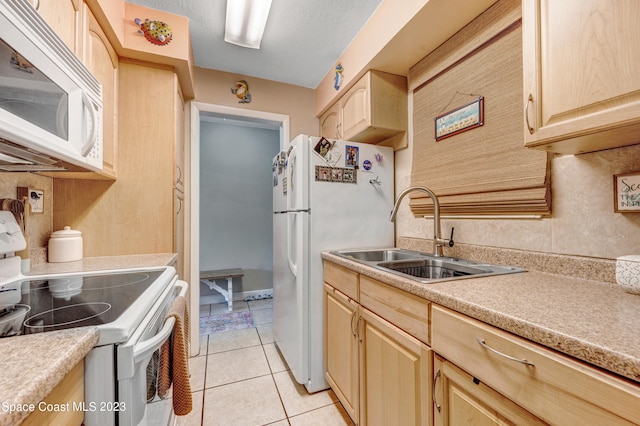 kitchen with white appliances, light brown cabinets, sink, and light tile floors