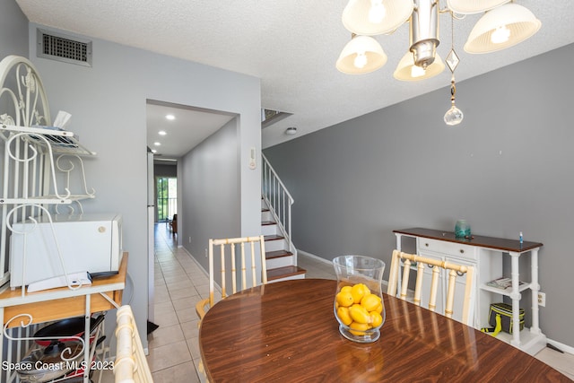 dining room with a textured ceiling and light tile floors