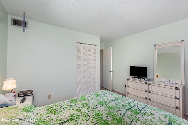 bedroom featuring a textured ceiling and a closet