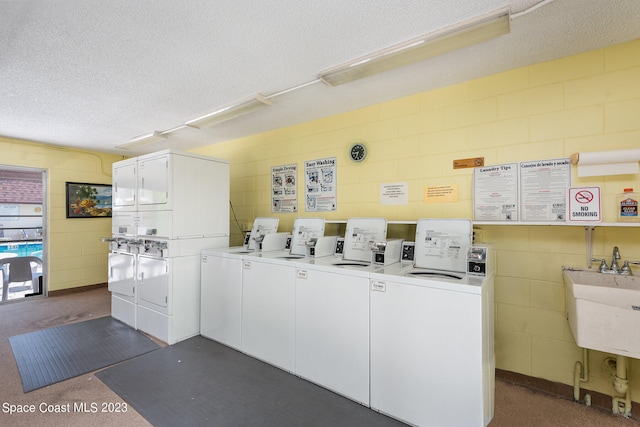 clothes washing area with a textured ceiling, washer and dryer, sink, and stacked washer and dryer