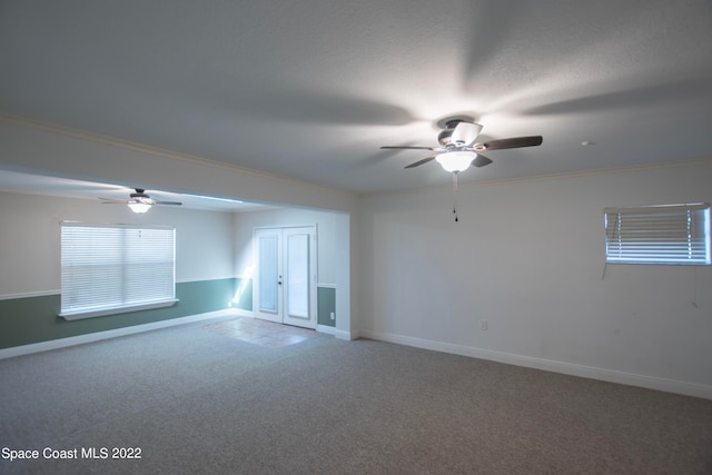 carpeted spare room featuring ceiling fan and crown molding