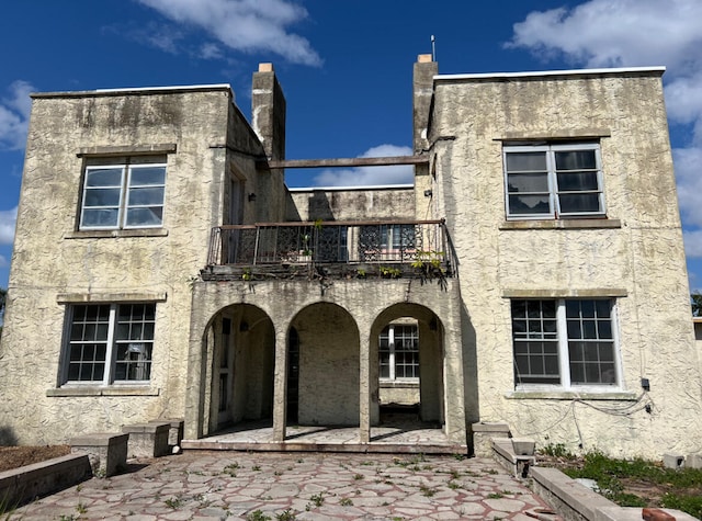 rear view of property with a balcony and a patio