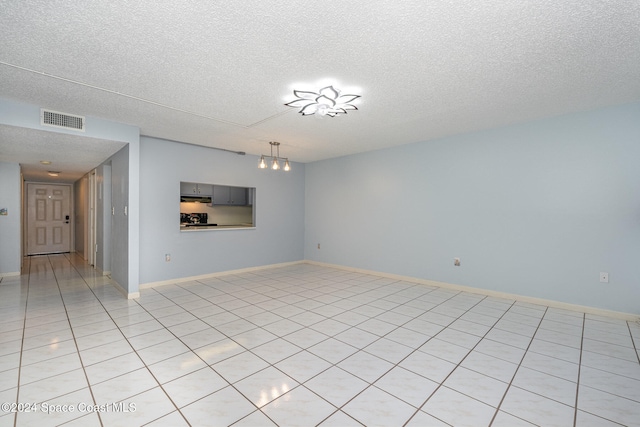 interior space featuring a textured ceiling and light tile patterned floors