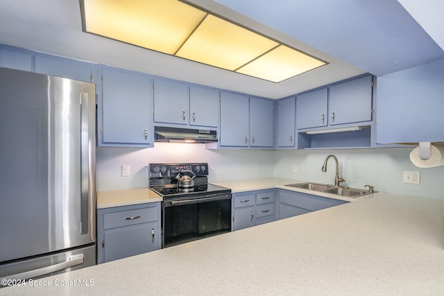 kitchen featuring black electric range, sink, and stainless steel fridge