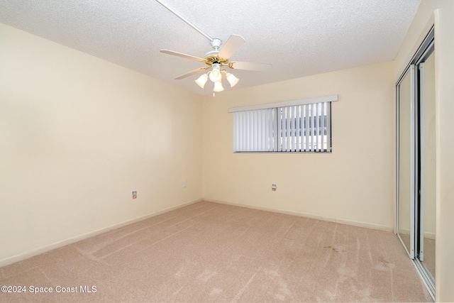 5800 N Banana River Blvd Unit 115, Cape Canaveral, FL 32920 - unfurnished bedroom with light carpet, a closet, a textured ceiling, and a ceiling fan