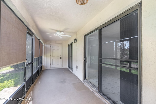 unfurnished sunroom featuring ceiling fan