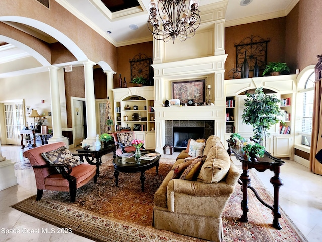 tiled living room featuring ornamental molding, decorative columns, a notable chandelier, and a fireplace