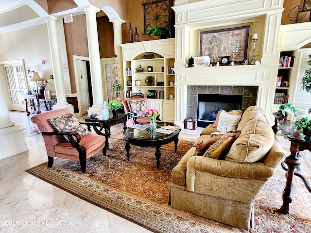 living room featuring a tiled fireplace, ornate columns, and light tile floors