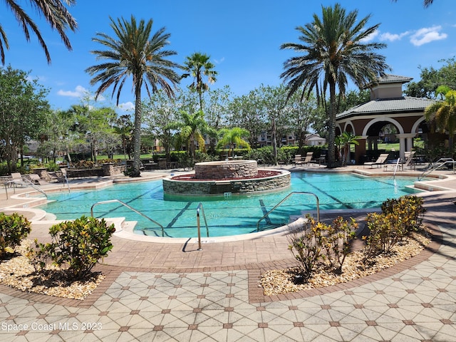 view of swimming pool featuring a patio and a hot tub