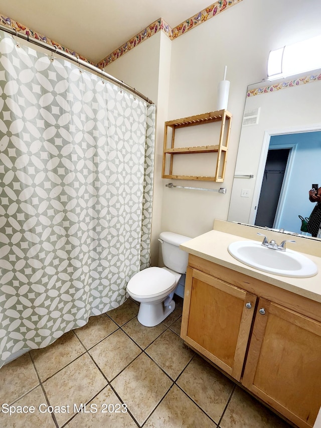 bathroom with tile flooring, large vanity, and toilet