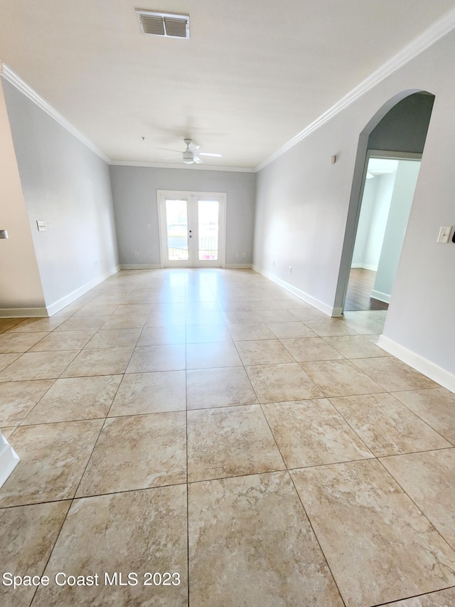 tiled spare room with ornamental molding, ceiling fan, and french doors