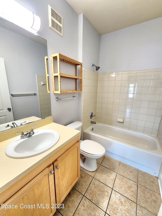 full bathroom featuring toilet, tile floors, tiled shower / bath combo, and vanity