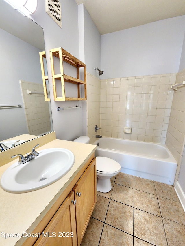 full bathroom with vanity, tile flooring, toilet, and tiled shower / bath