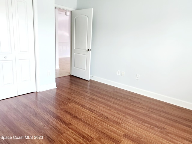 unfurnished room with dark wood-type flooring