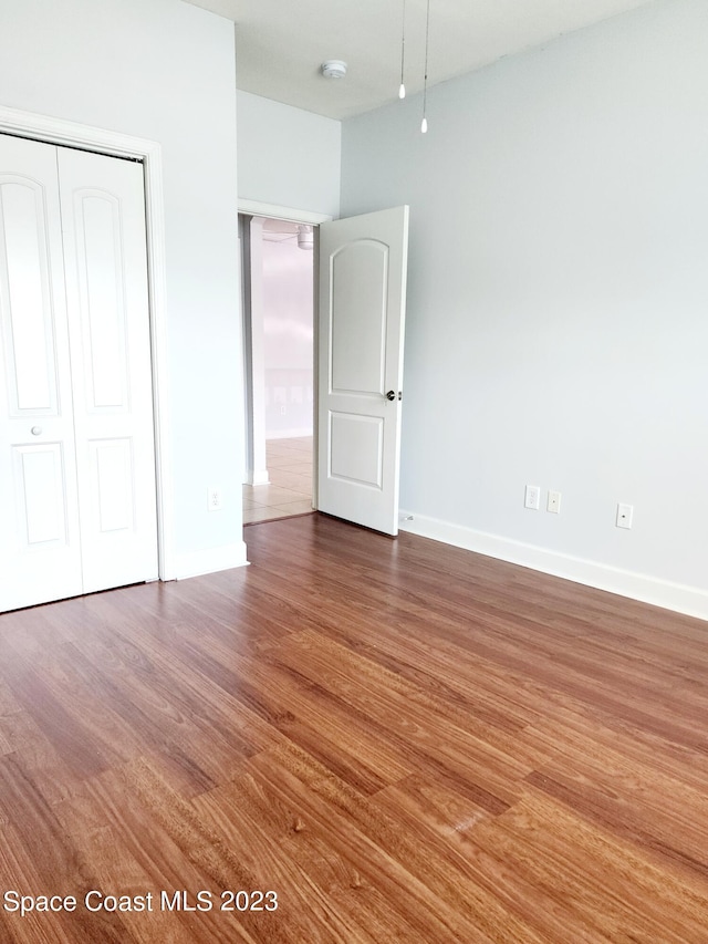 unfurnished bedroom featuring a closet and dark hardwood / wood-style flooring