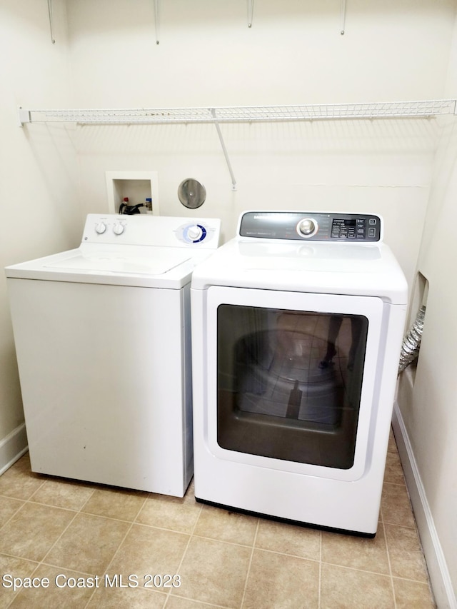 laundry room featuring hookup for a washing machine, washing machine and clothes dryer, and light tile flooring