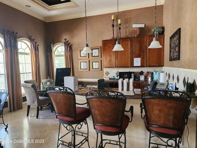 kitchen with crown molding, light tile floors, tasteful backsplash, a breakfast bar area, and pendant lighting